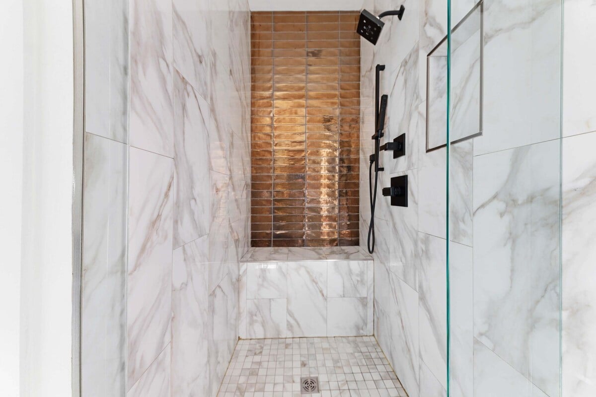 Luxurious walk-in shower with marble-inspired tile and rainfall head