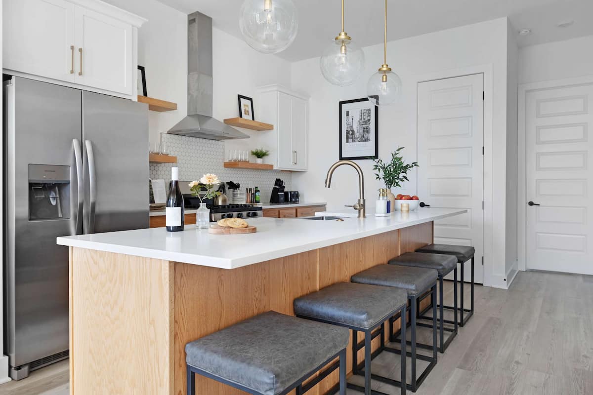 Modern kitchen with a spacious pantry and a large island with five barstools, ideal for cooking and casual dining