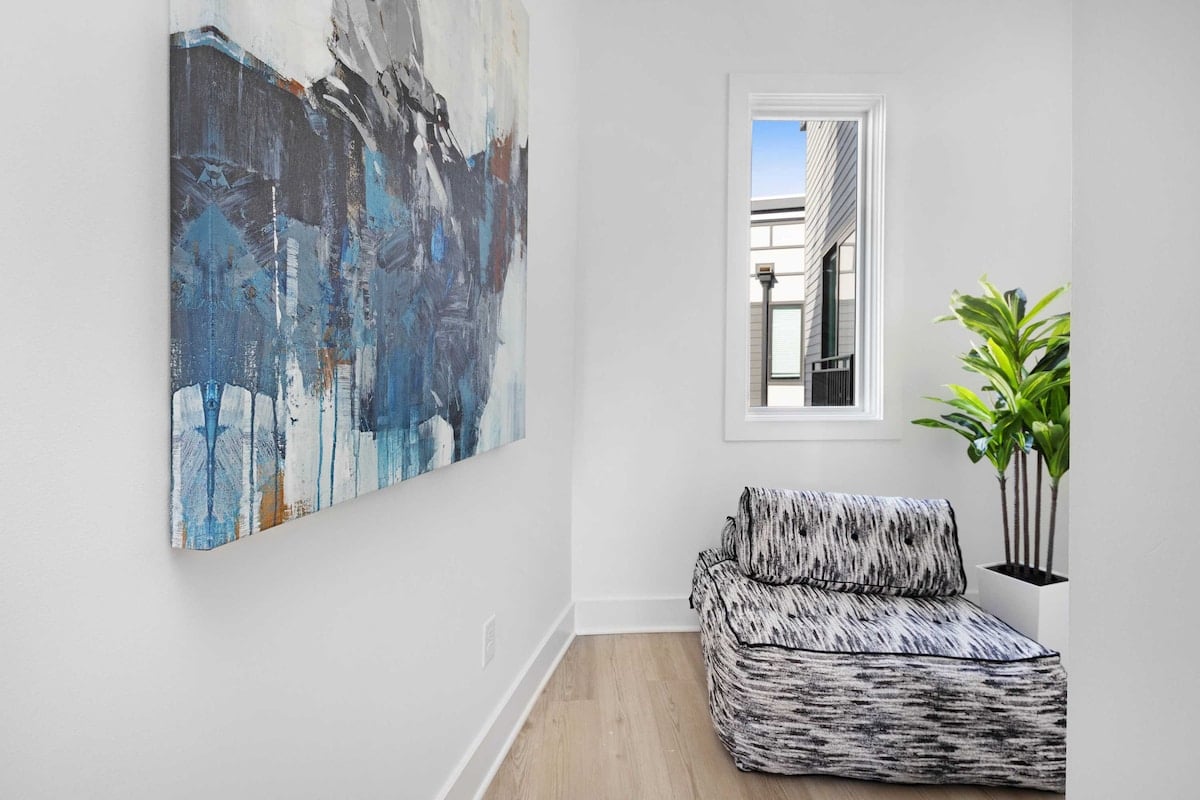 Bright hallway lounge with modern artwork and a cozy reading chair.