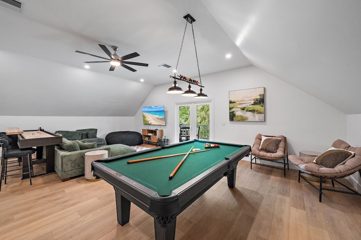 Fun game room located in the main house on the second floor. Gaming options include: a poker table, pool table, infinity game table, shuffleboard, and TV!