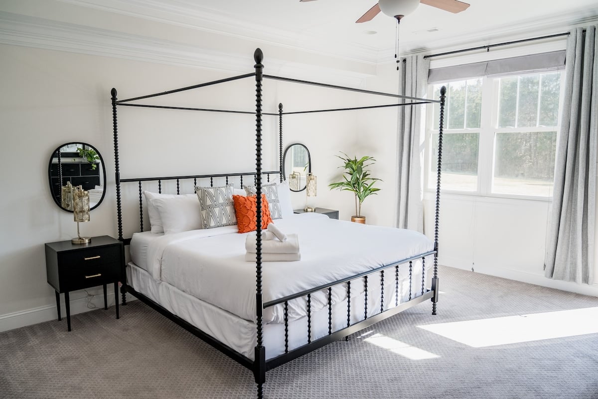 Spacious downstairs primary bedroom with canopy king bed
