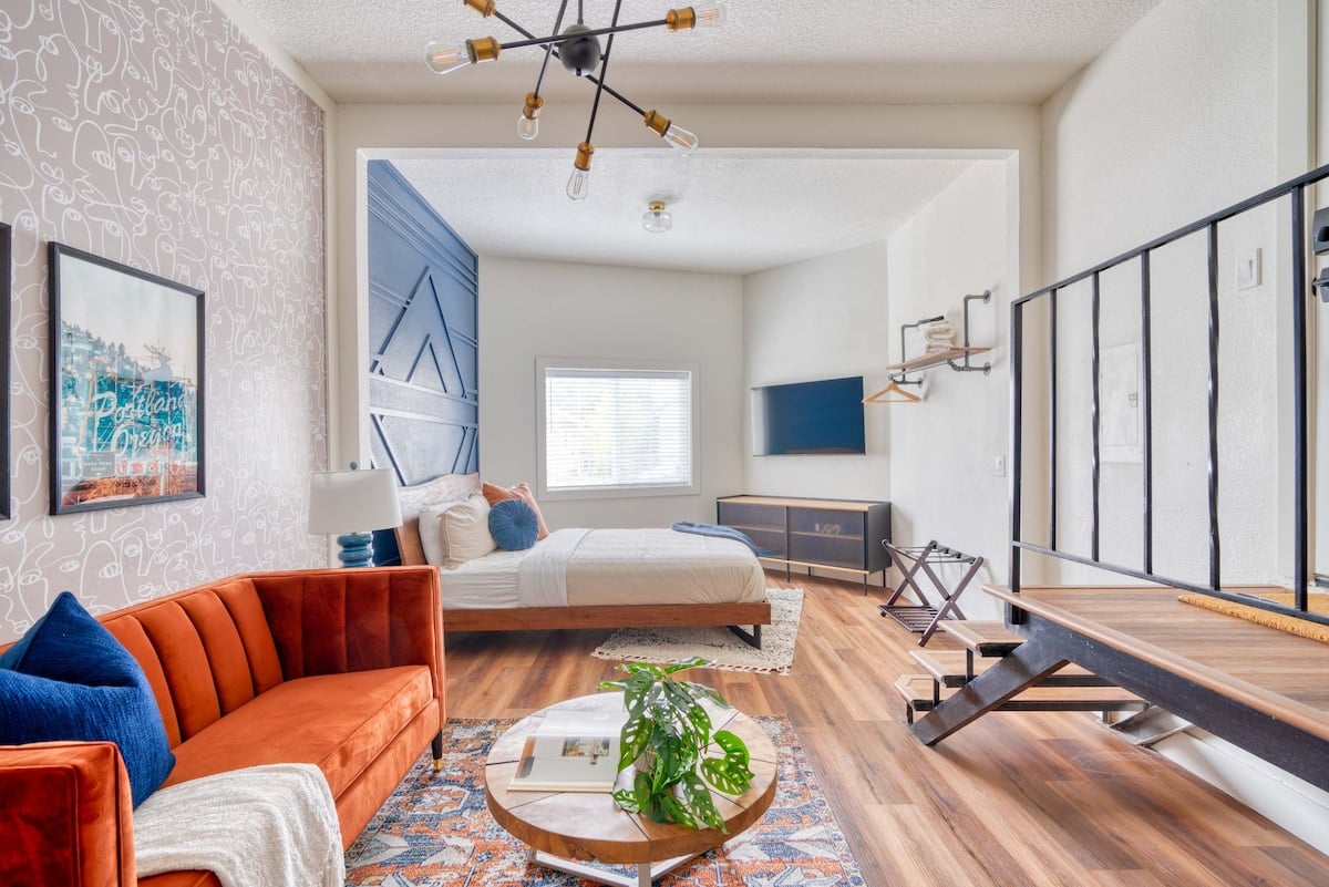 **CAPTION:** Discover luxury and contemporary elegance at "Property" in Portland, US. This sophisticated space features a modern architectural style with an inviting open-plan layout. The room's cozy atmosphere is highlighted by a rich color palette of warm terra cotta and deep navy, with sleek wooden floors and geometric accents. Perfect for discerning travelers seeking comfort and style, the property boasts a seamless blend of classic and modern aesthetics, making it an ideal retreat in the city.