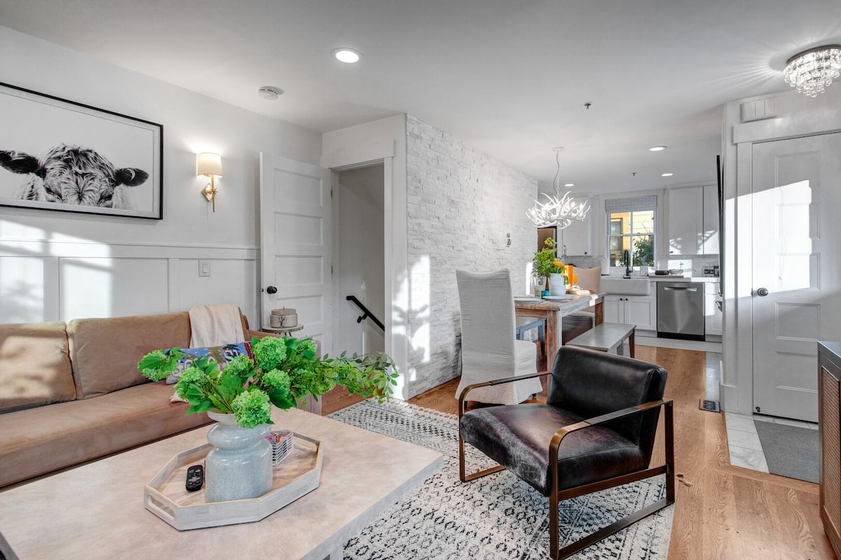 **CAPTION**: Discover "Property," a luxurious travel retreat in Park City, US, boasting a modern rustic architectural style. The bright and airy atmosphere is enhanced by natural light pouring through large windows, accentuating the whitewashed brick walls and sleek hardwood floors. With a neutral color palette highlighted by vibrant green accents, this property offers a cozy yet sophisticated ambiance. Ideal for discerning travelers seeking comfort and style amidst breathtaking mountain views.