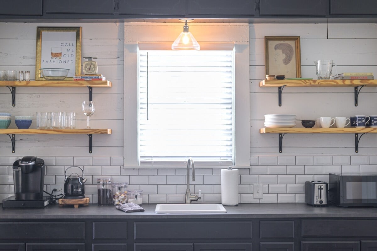 **CAPTION:** The Property in Waco embodies a modern farmhouse style, featuring a charming kitchen with rustic open shelving and sleek black cabinetry. The crisp white shiplap walls paired with the classic subway tile backsplash create a serene and inviting atmosphere. Warm lighting and wood accents add a touch of coziness, making it an ideal escape for travelers seeking comfort and style. The neutral color palette enhances the tranquil and homey feel of this luxurious retreat.

2. **META DESCRIPTION:** Property - Modern farmhouse kitchen with rustic open shelving | Book at Journey.com