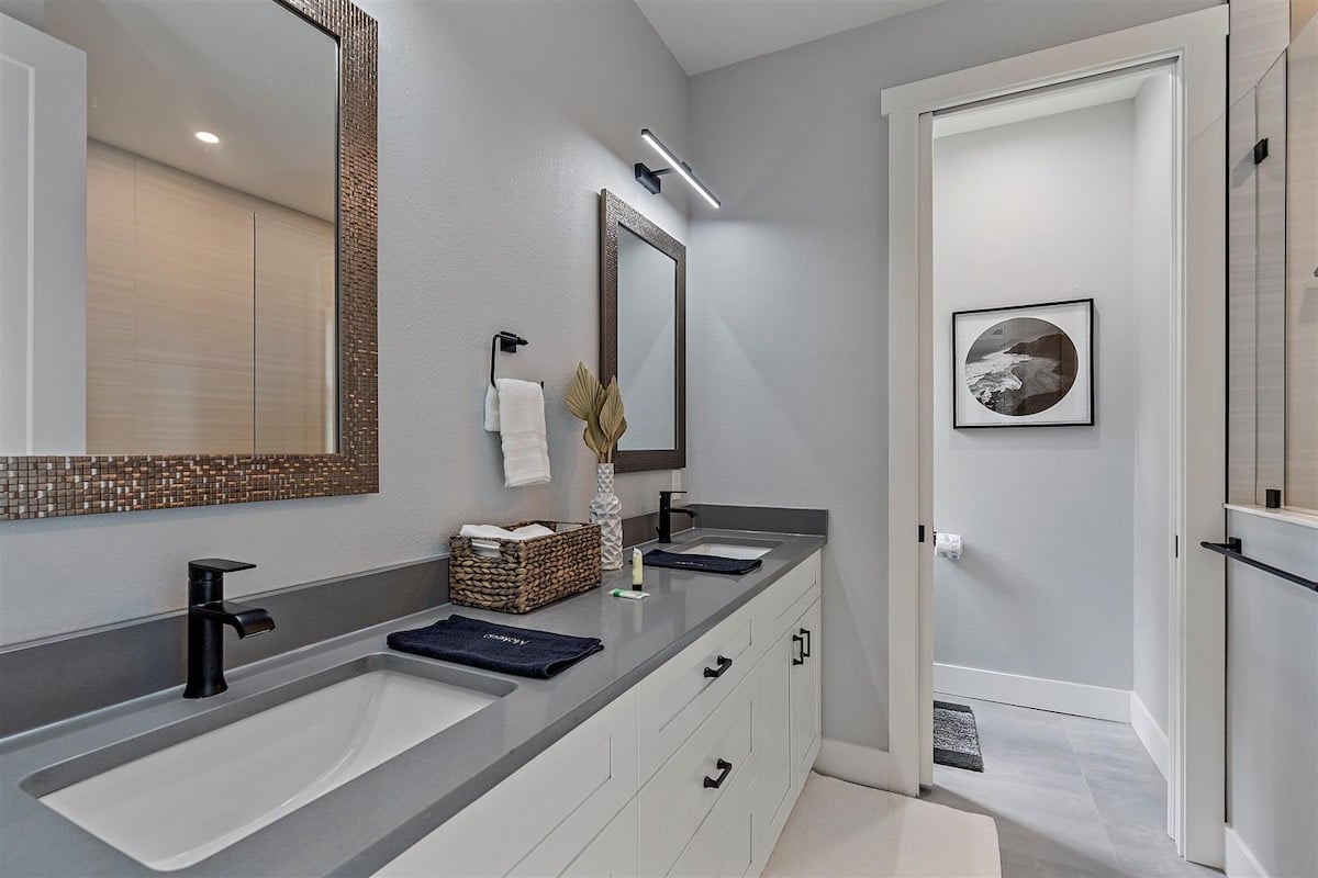 Full bath located through Bedroom 3 with standing shower and a double sink vanity.
