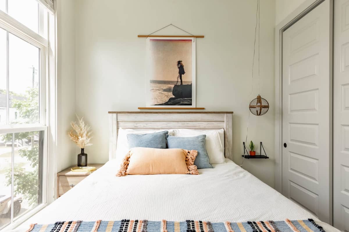 This cozy queen bedroom is filled with natural light and charming decor touches.