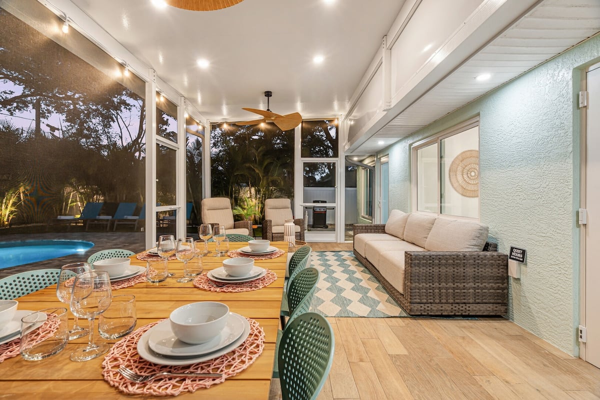 Behold the ideal spot for a delightful evening meal! The outdoor dining table is bathed in the warm glow of perfectly arranged string lights, creating a charming setting for your dinner.