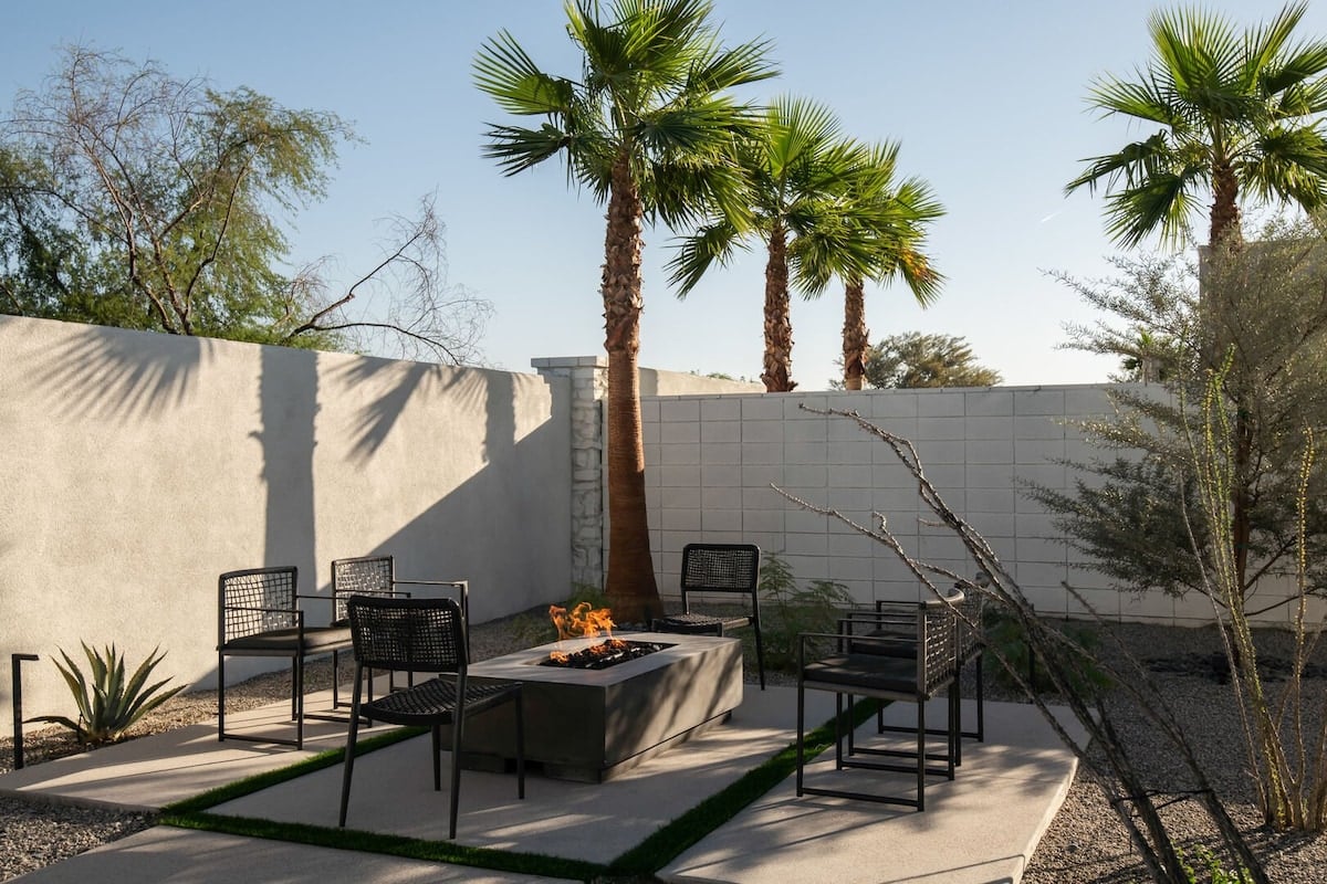 Gather around the cozy outdoor gas fire pit lounge area, beautifully surrounded by palm trees and desert landscaping.