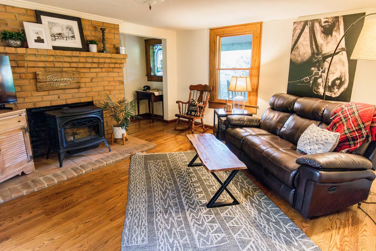 Main floor Living Room includes comfortable couch w/ recliner, accent chair, rocking chair, and TV with basic channels, Chromecast, dvd player, & dvd collection.