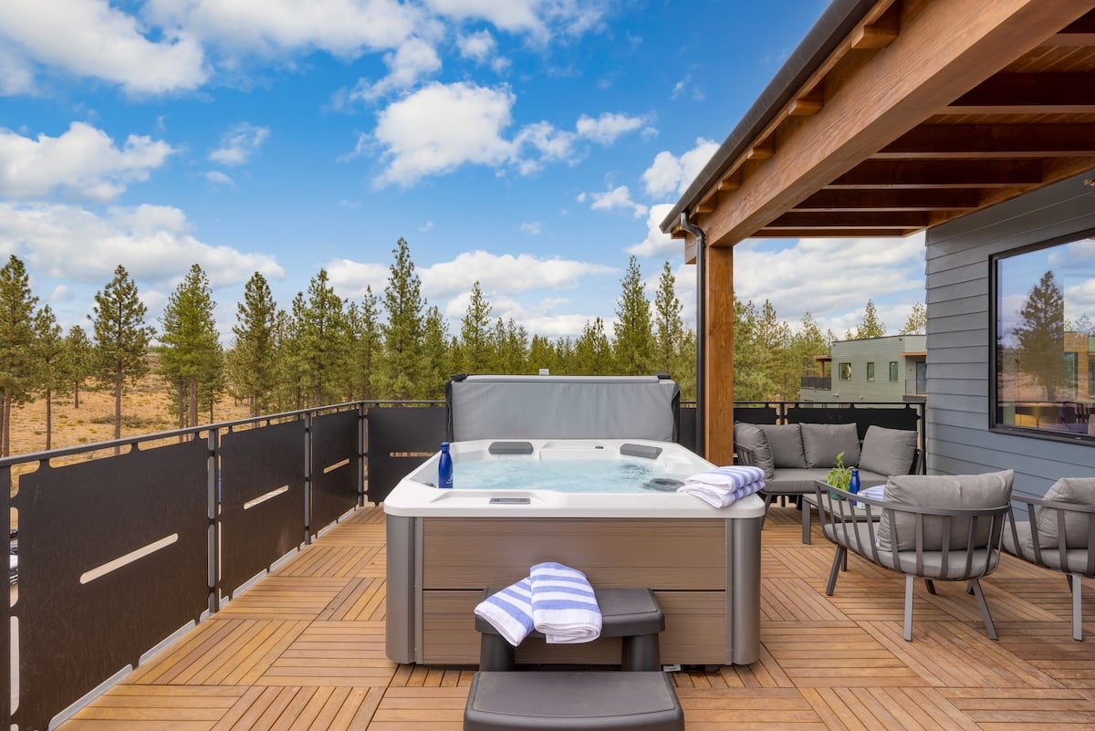 Hot tub with tranquil mountain-sky views.