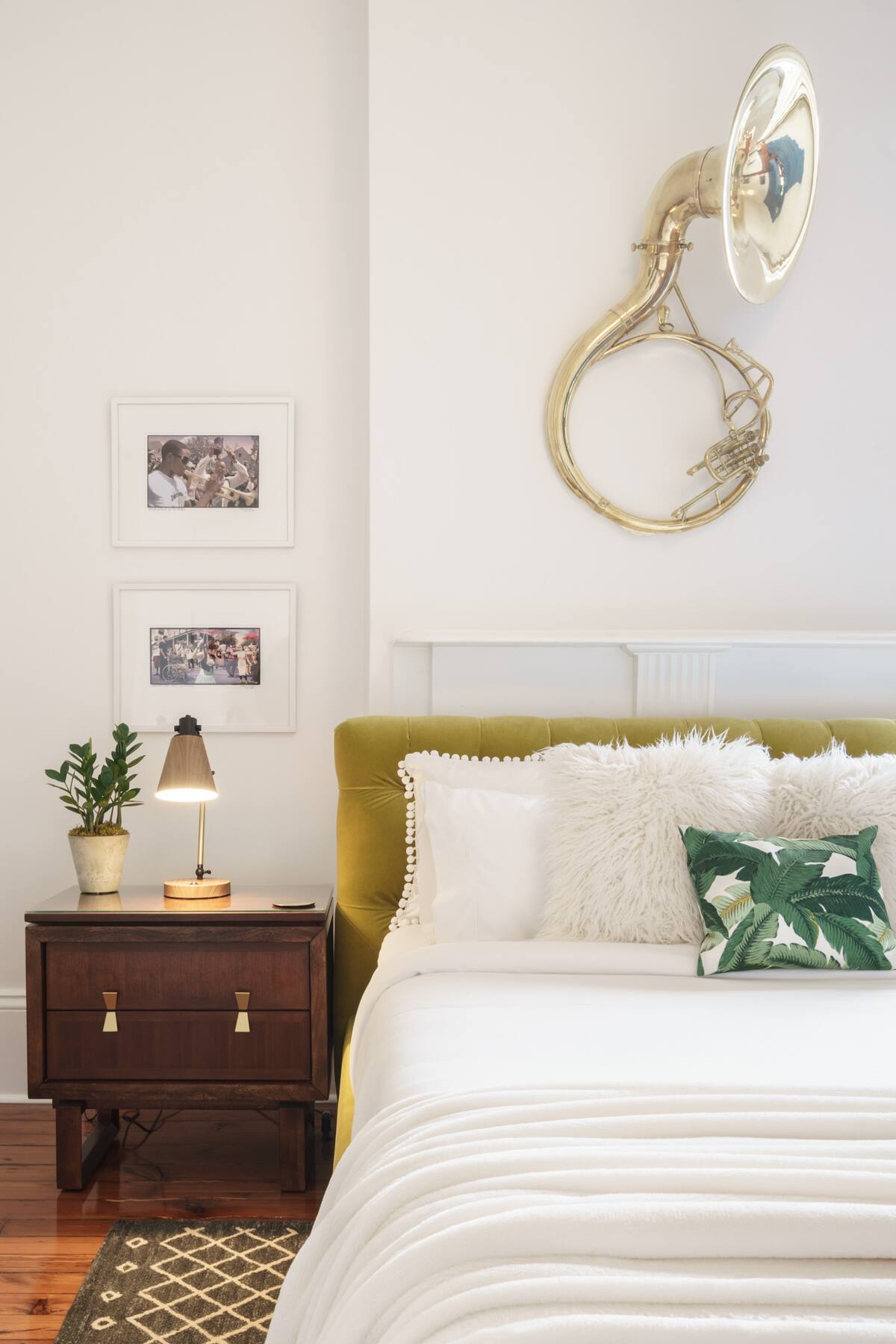 The stylish bedroom features a chartreuse velvet bed with luxurious fabrics and original photography to admire.
