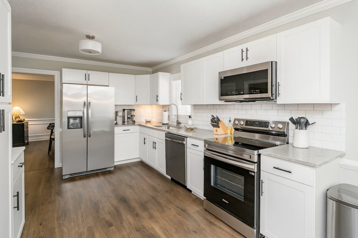 The fully-stocked kitchen has granite countertops, stainless steel appliances, and everything needed to cook meals.