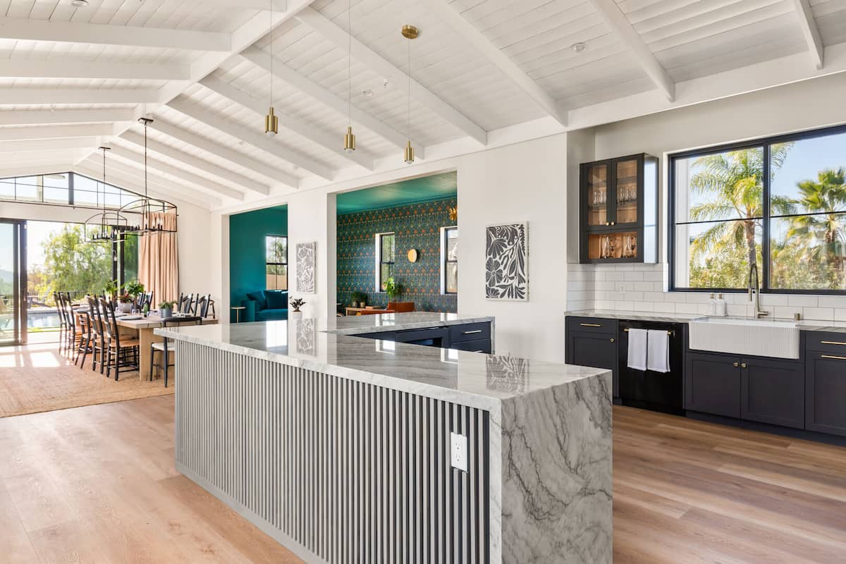 An L-shaped marble waterfall island is the centerpiece of this room