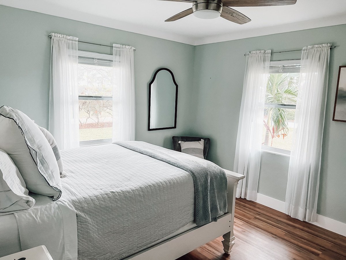 Wall mounted mirror, ceiling fan, and a chair