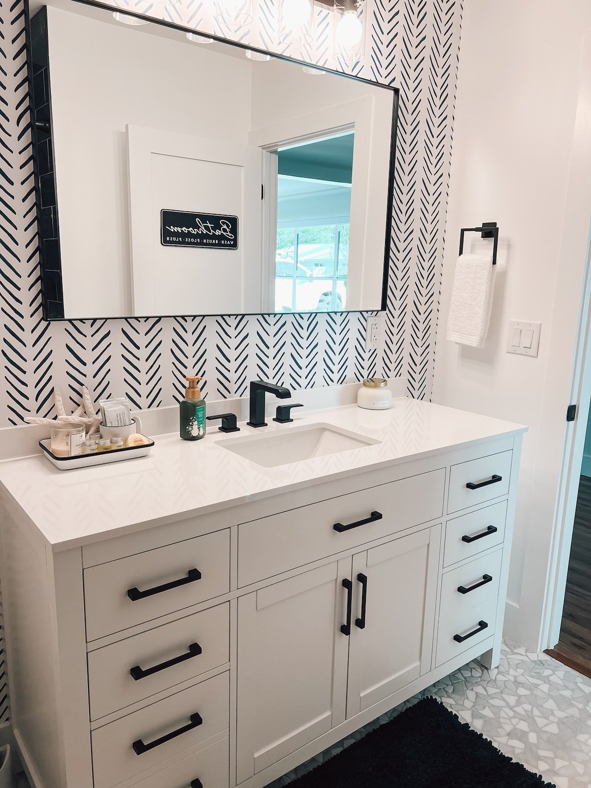 Large vanity, bright lights, and an accent wall to tie it all together