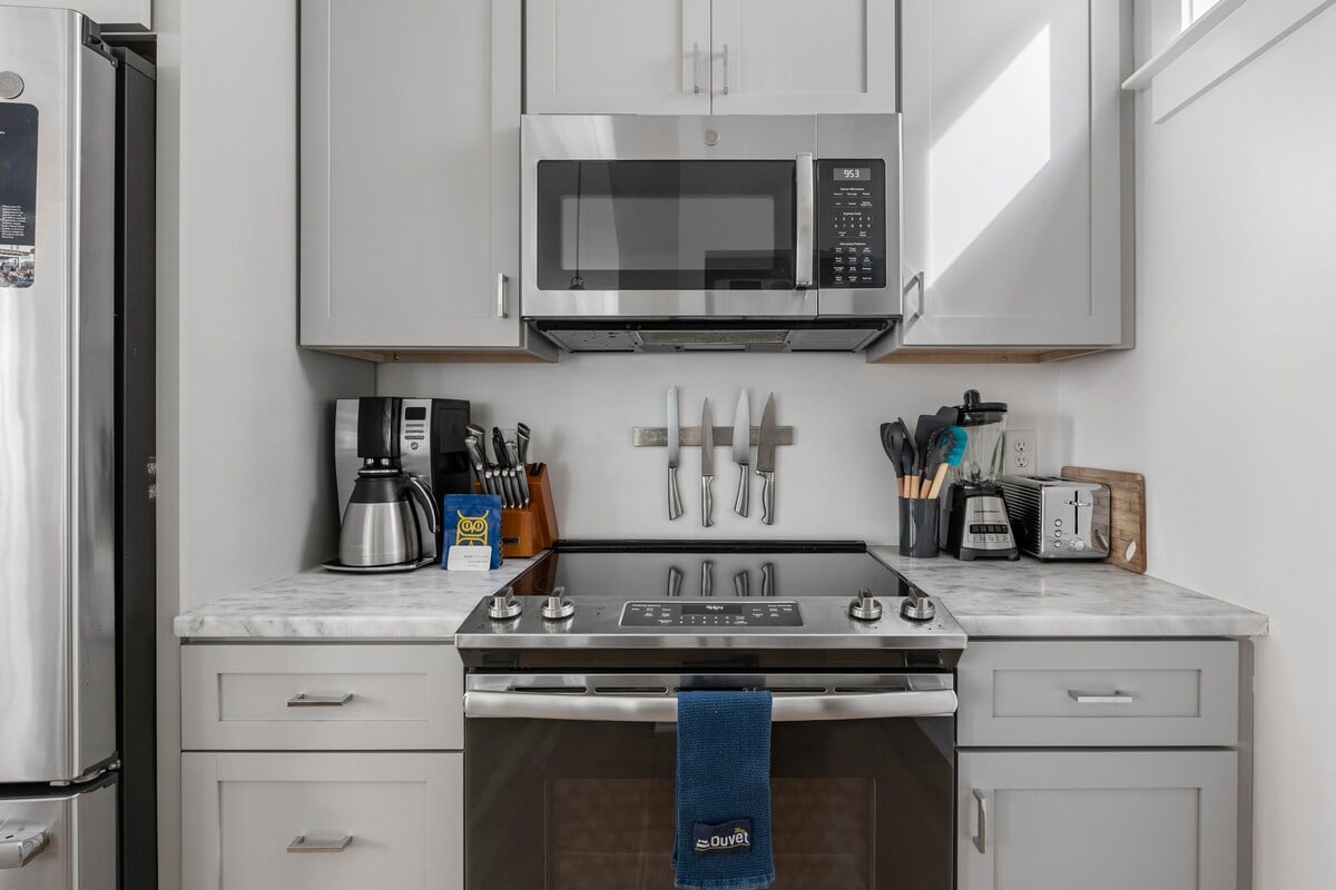 **CAPTION:** 

Discover the charm of "Property," a luxurious travel destination in Charleston, US. This stunning kitchen blends modern elegance with functional design, featuring sleek stainless steel appliances and a pristine marble countertop. The soft gray cabinetry complements the serene, light-filled atmosphere, inviting culinary creativity. Ideal for travelers seeking a home-like comfort, the kitchen’s organized, minimalist style creates a welcoming ambiance. Perfect for both gourmet experiences and relaxed gatherings.