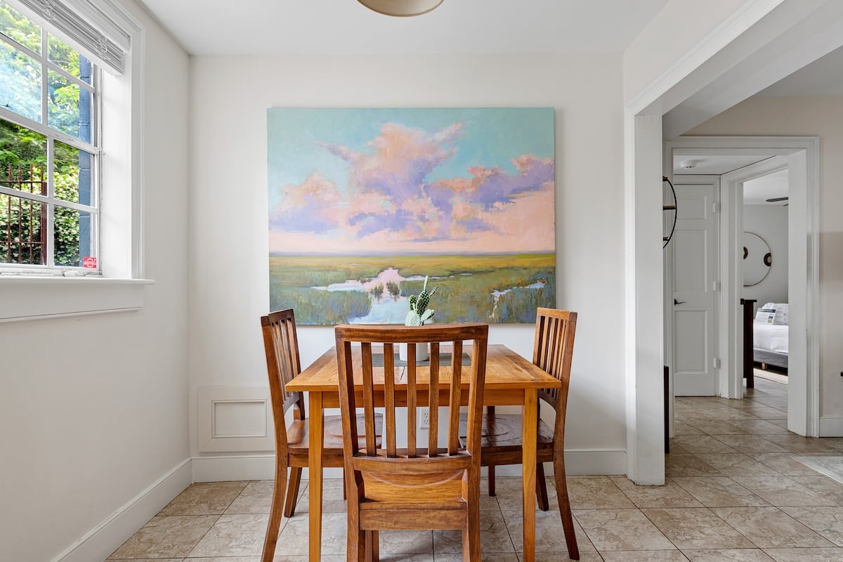**CAPTION:** Discover the charm of Charleston with "Property," a luxurious travel destination where modern design meets Southern elegance. This inviting space features a bright, airy atmosphere complemented by a serene painting evoking a peaceful landscape. The interior boasts a neutral color palette with natural wood accents, promoting a sense of warmth and tranquility. Perfect for travelers seeking a blend of contemporary comfort and classic Southern style.