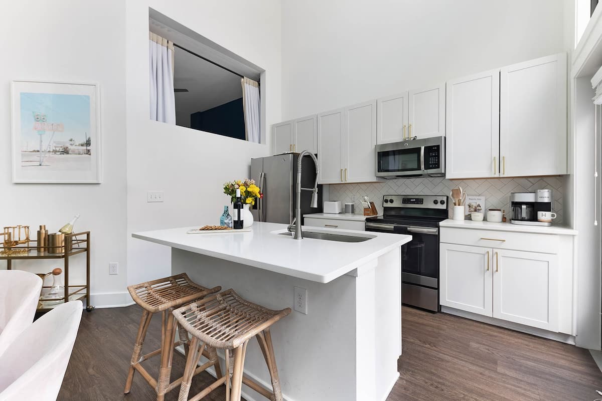 The kitchen is equipped with stainless steel appliances, a Keurig Duo coffee maker, and an island with extra bar seating for added convenience.