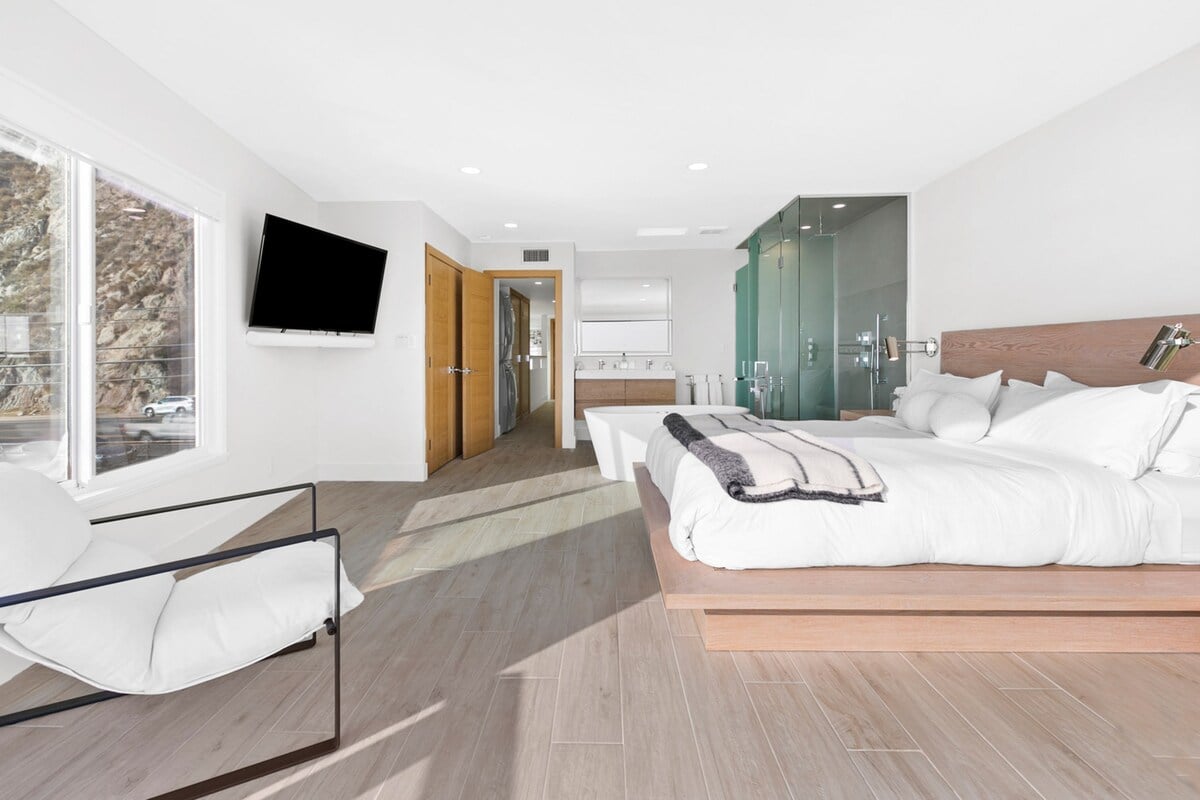 Master bedroom with smart TV and open bathroom area