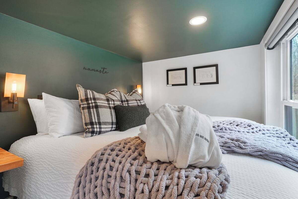 Cozy bedroom space with King size bed and large glass window at the foot of the bed.