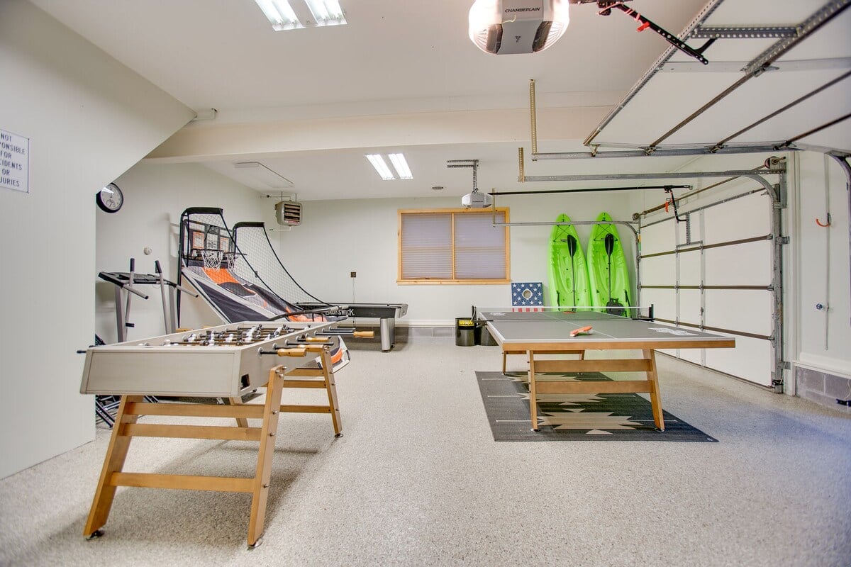 This game room is equipped with foosball, ping pong, air hockey, a basketball arcade game, a treadmill, Kan Jam, corn hole boards, and 2 kayaks!!
