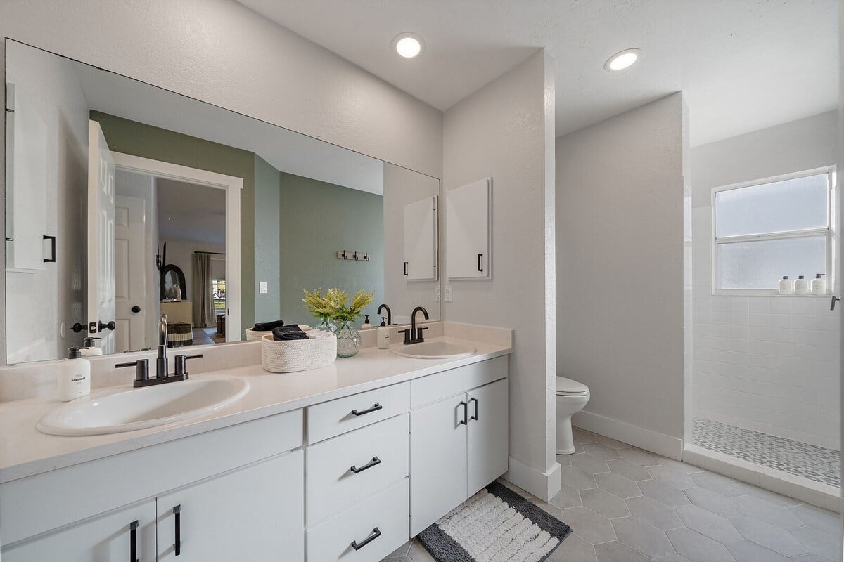Bathroom 1 is equipped with a standing shower and double vanity, and is accessible from the hallway/bedroom 1.