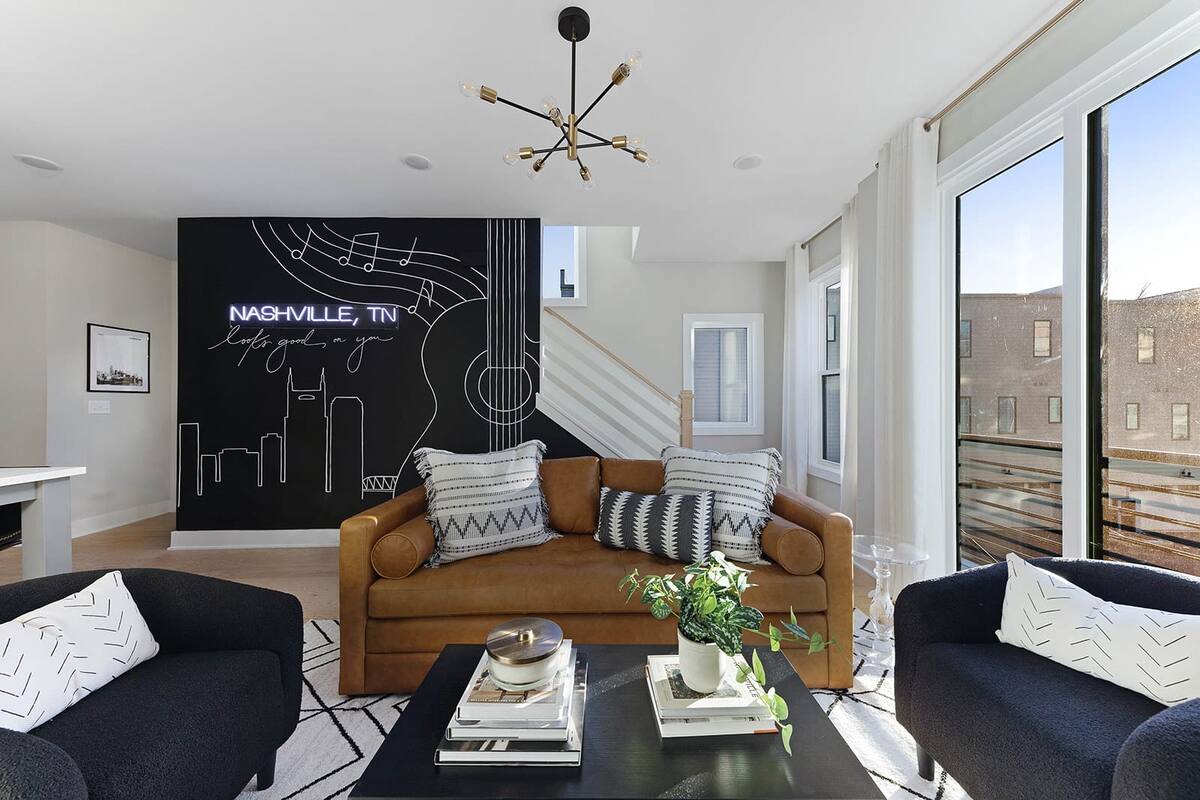 The living room features a stylish, city-inspired accent wall that warmly welcomes you to Nashville.