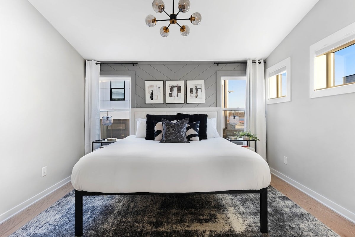 The third-floor bedroom features a king bed and an abundance of windows, allowing plenty of natural light to fill the space.