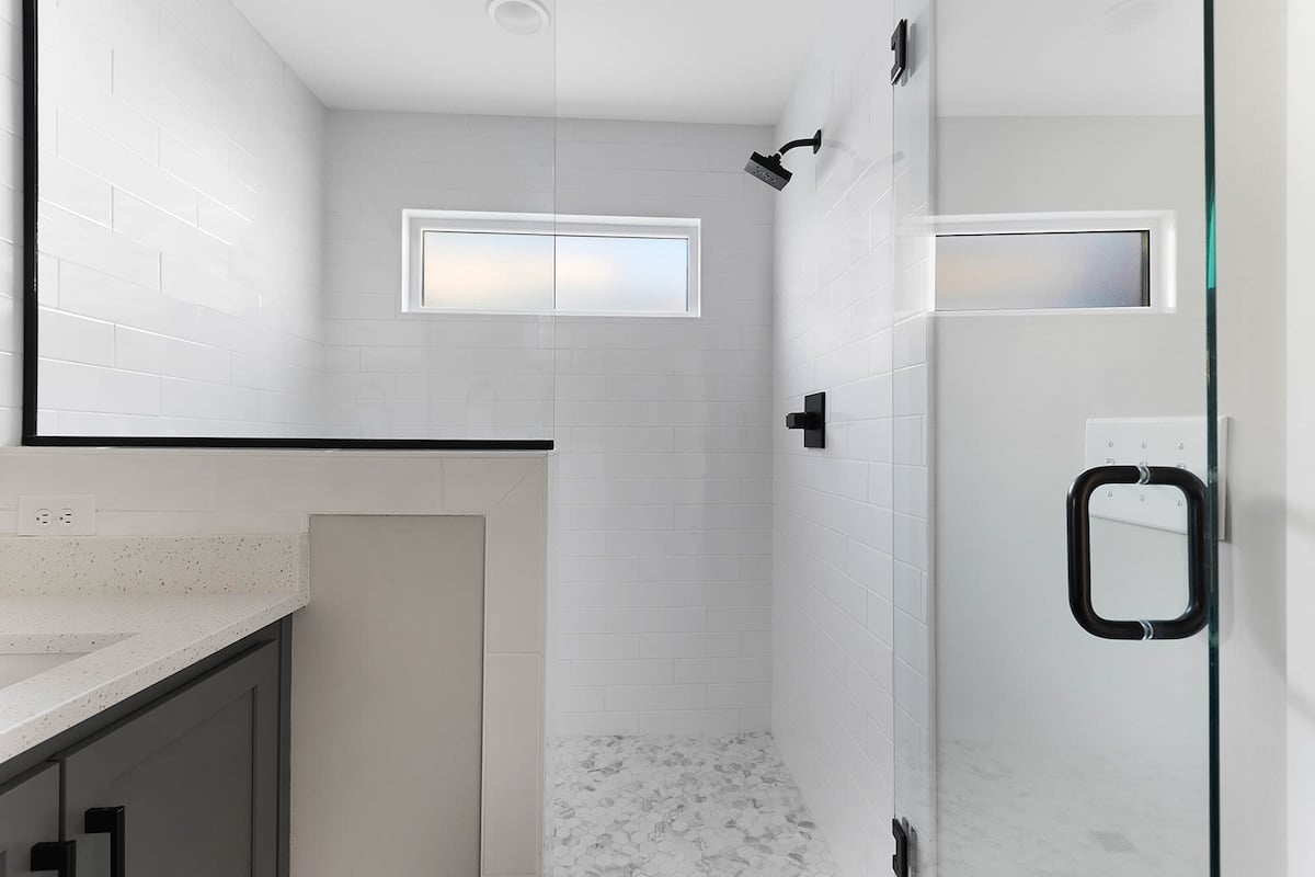 The master bathroom features a spacious walk-in shower for a luxurious experience.