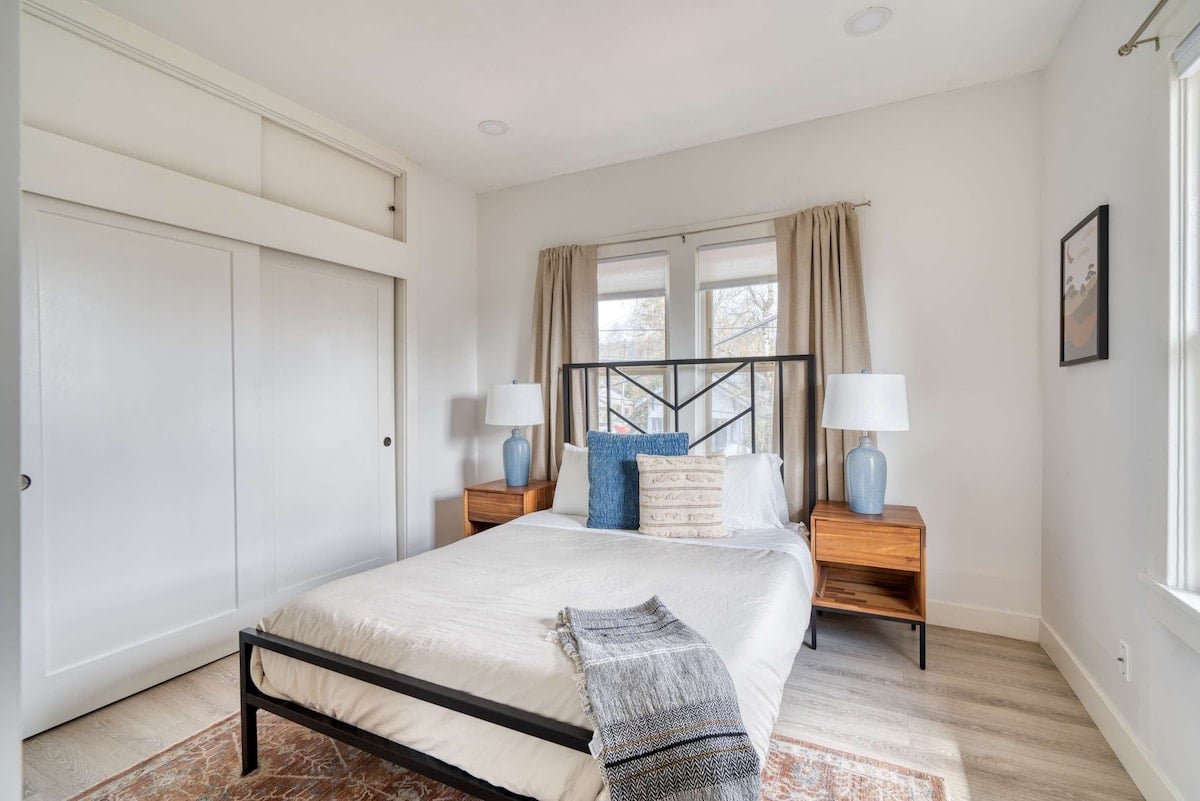 **CAPTION:** Nestled in Portland, “Property” exudes a contemporary charm with its minimalist architectural style and serene atmosphere. The room features a blend of soft neutrals and light wood tones, accented by modern furnishings. Crisp white walls, wooden floors, and large windows infuse the space with natural light, creating a welcoming ambiance for travelers seeking comfort and elegance. Perfect for those desiring a stylish retreat infused with tranquility.