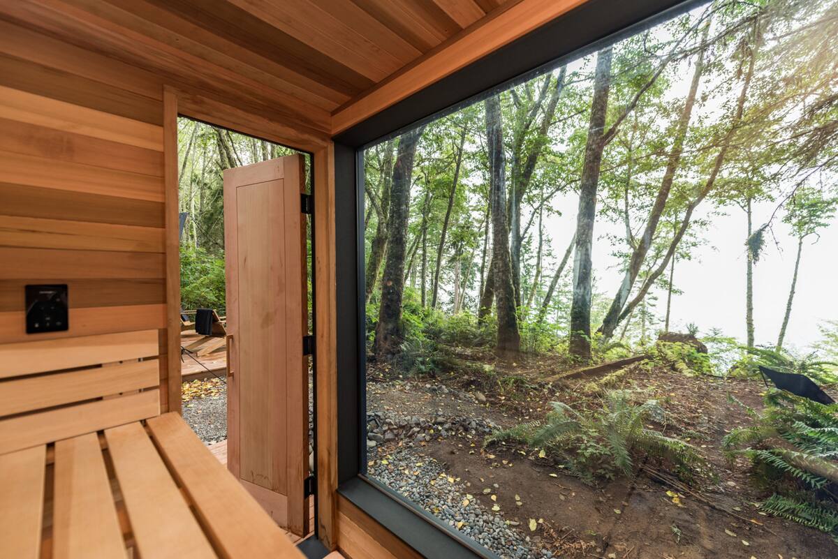 The sauna interior blends Scandinavian simplicity with cedar warmth—offering sea views and deep restoration.
