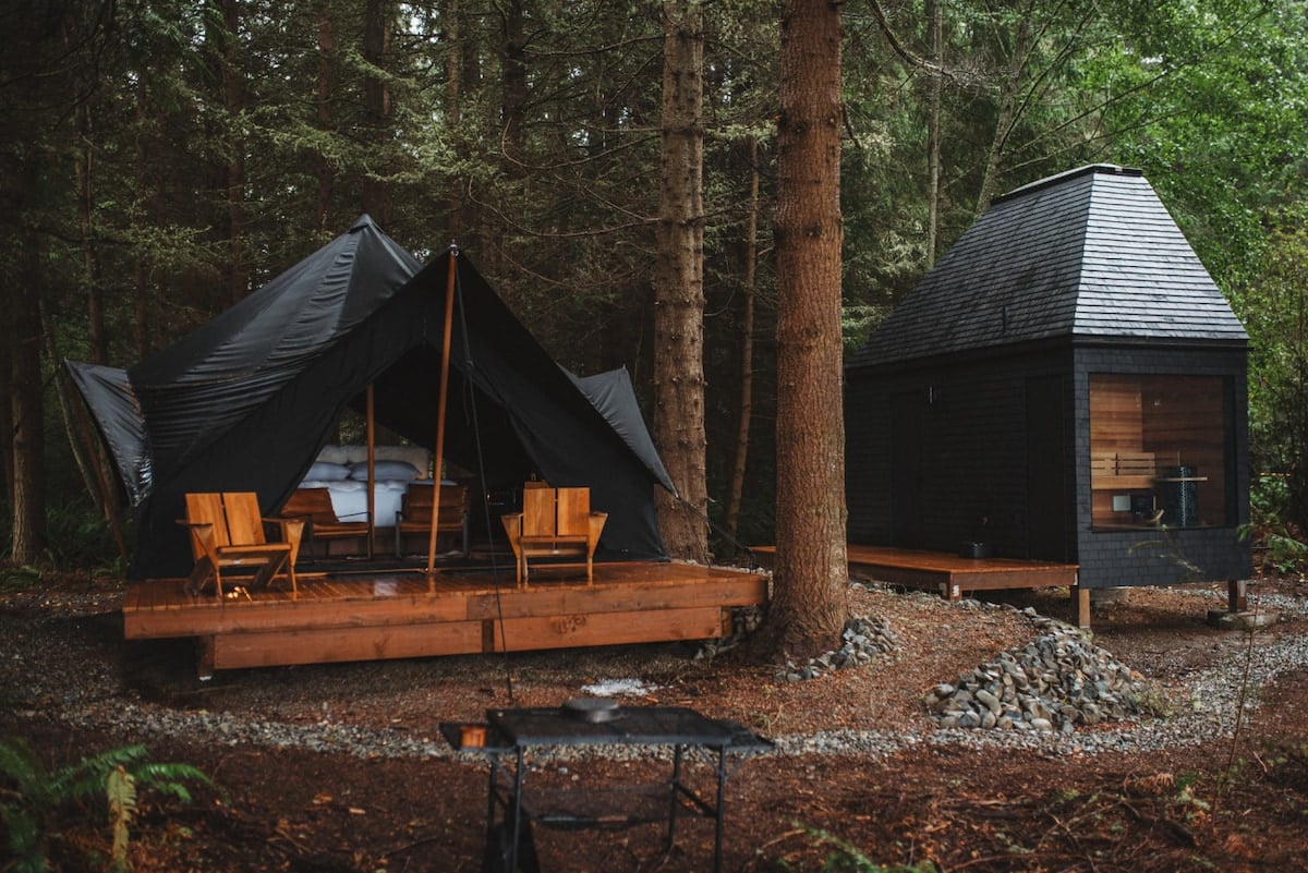 CAPTION: Nestled amidst the lush forests of Port Angeles, “Property” offers an enchanting escape with its modern tented cabins. The minimalist design features earthy tones and natural wood elements, blending seamlessly with the surrounding wilderness. The cozy ambiance invites travelers seeking a serene retreat, complemented by the site's integration with nature. Ideal for luxury glamping, this property promises an immersive experience for nature lovers and adventure seekers alike.