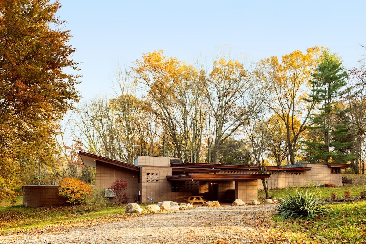 The entrance is “hidden” at the back of the carport.