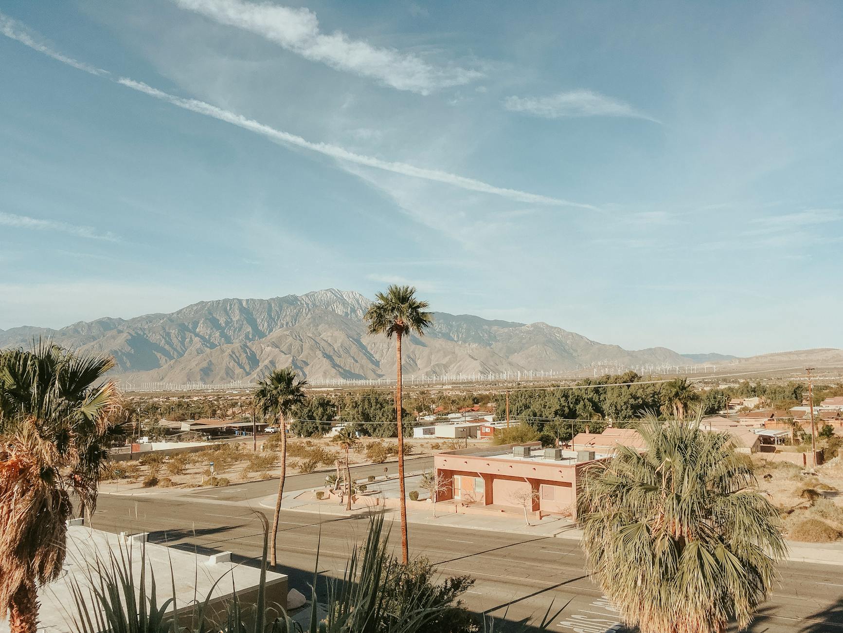 Stunning desert landscape in Palm Springs, CA, featuring mountains, palm trees, and clear skies.