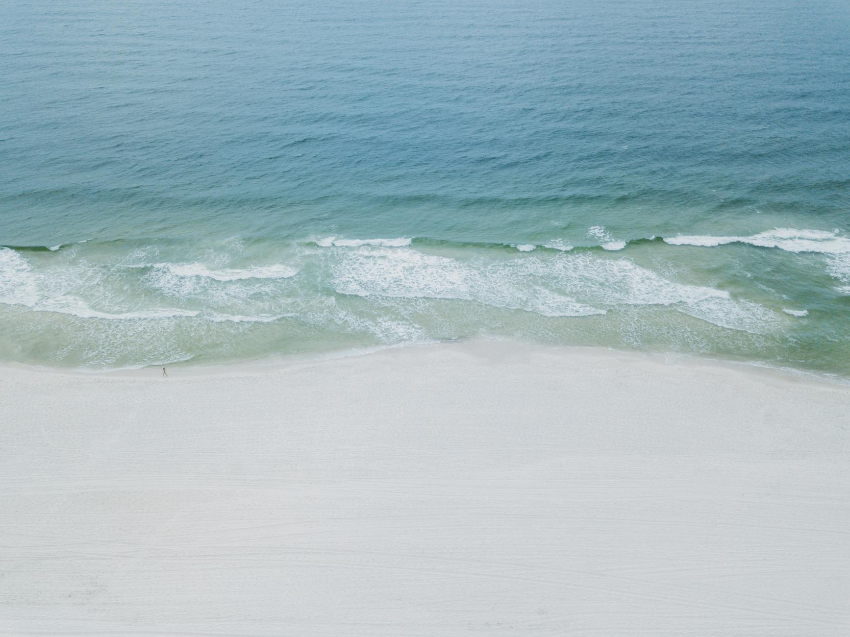 A serene aerial image showcasing the tranquil beaches and clear waters of Orange Beach, Alabama.
