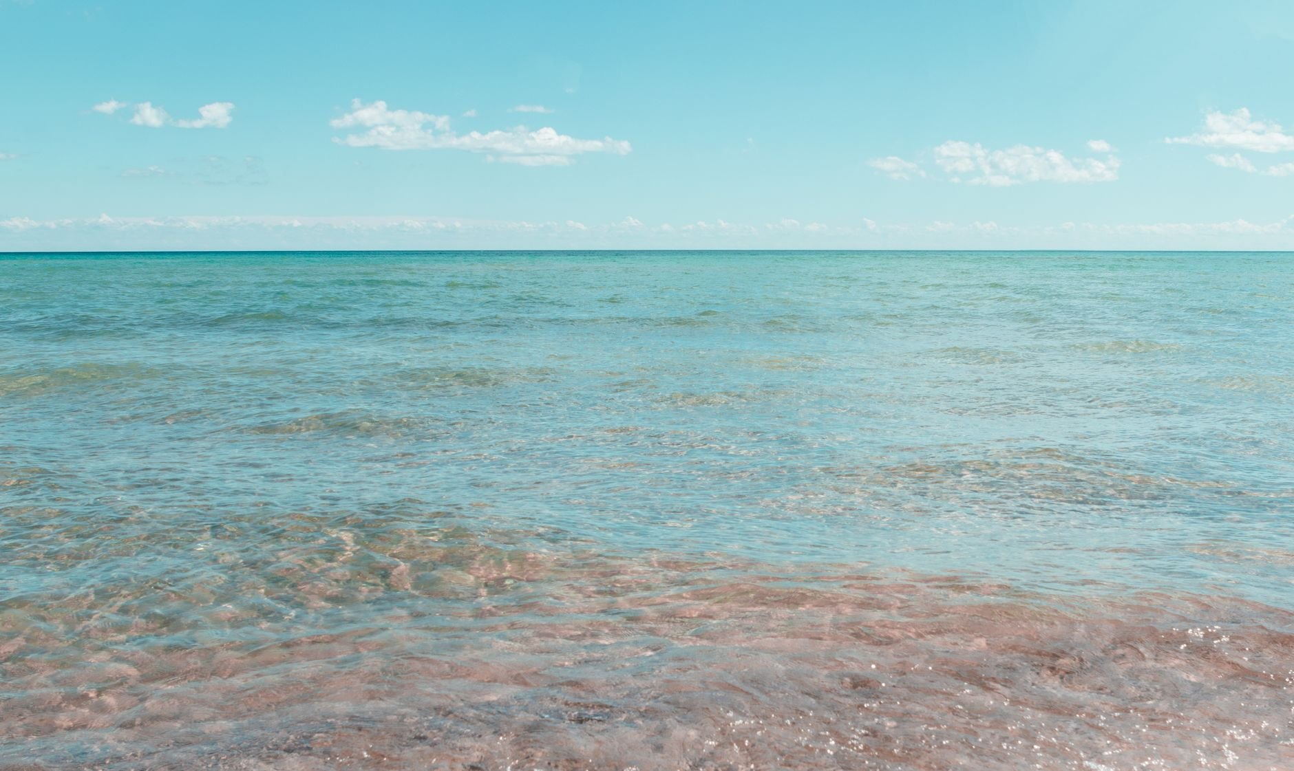 Tranquil shoreline scene with clear skies at East Tawas, Michigan, USA.