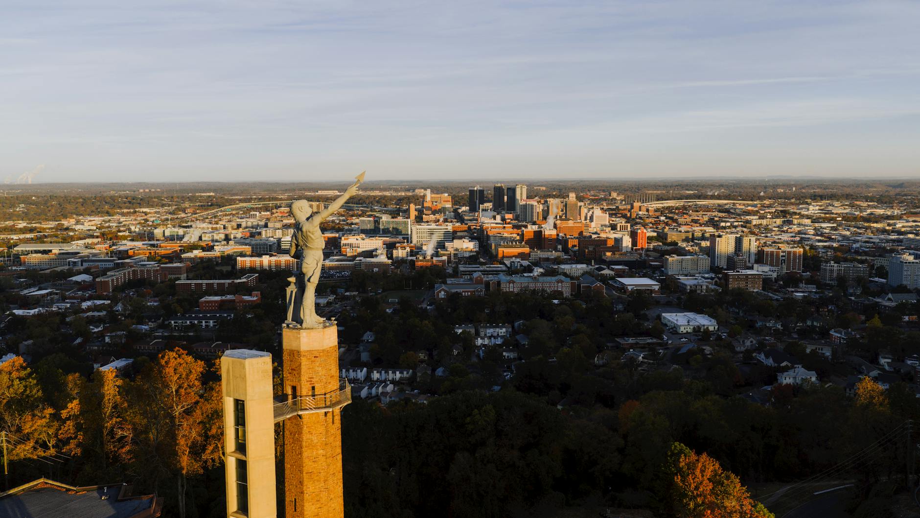 Drone capture of the Vulcan statue with Birmingham city skyline at sunset, Alabama.