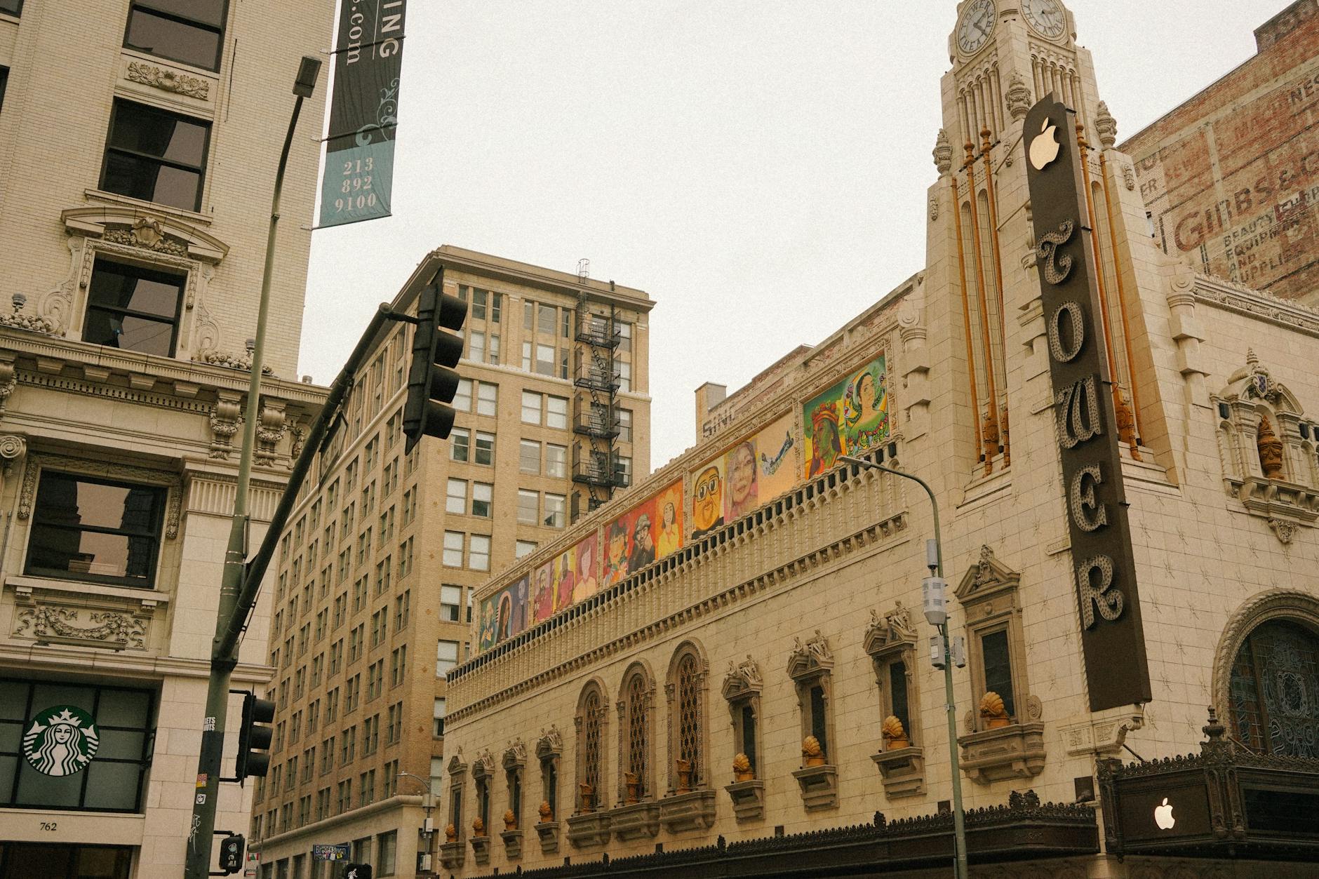 Urban scene featuring a historic theater with intricate architecture and street view.